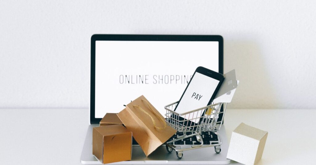 オンラインと実店舗の初売りを比較するイメージ。パソコン画面とショッピングモールの様子が対比される